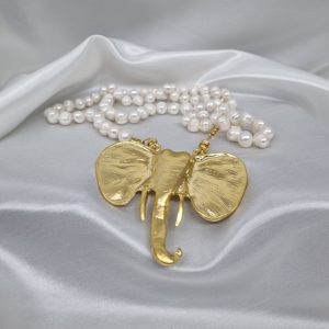 Perlas cultivadas que reflejan la pureza y la belleza. Elefante de bronce, símbolo de buena suerte y fortuna.