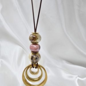 Este colgante combina la calidez del dorado con la autenticidad del cuero y la delicadeza de la porcelana griega. Cada pieza está cuidadosamente elaborada para reflejar un estilo natural, moderno y atemporal.